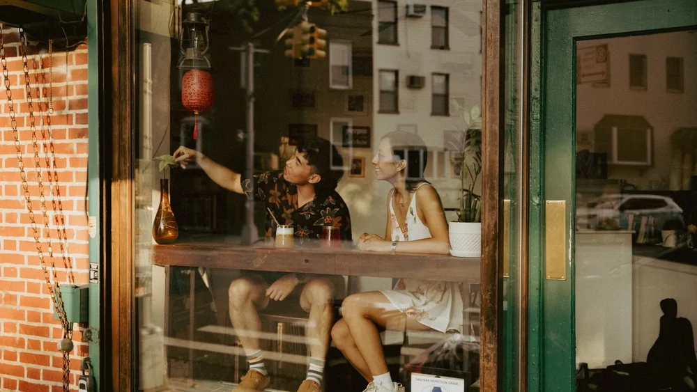 Photo of two people in the windows of Larry's Ca Phe in Williamsburg.